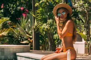 woman relaxing in sunlight representing tanning sprays vs tanning drops in a tanning routine